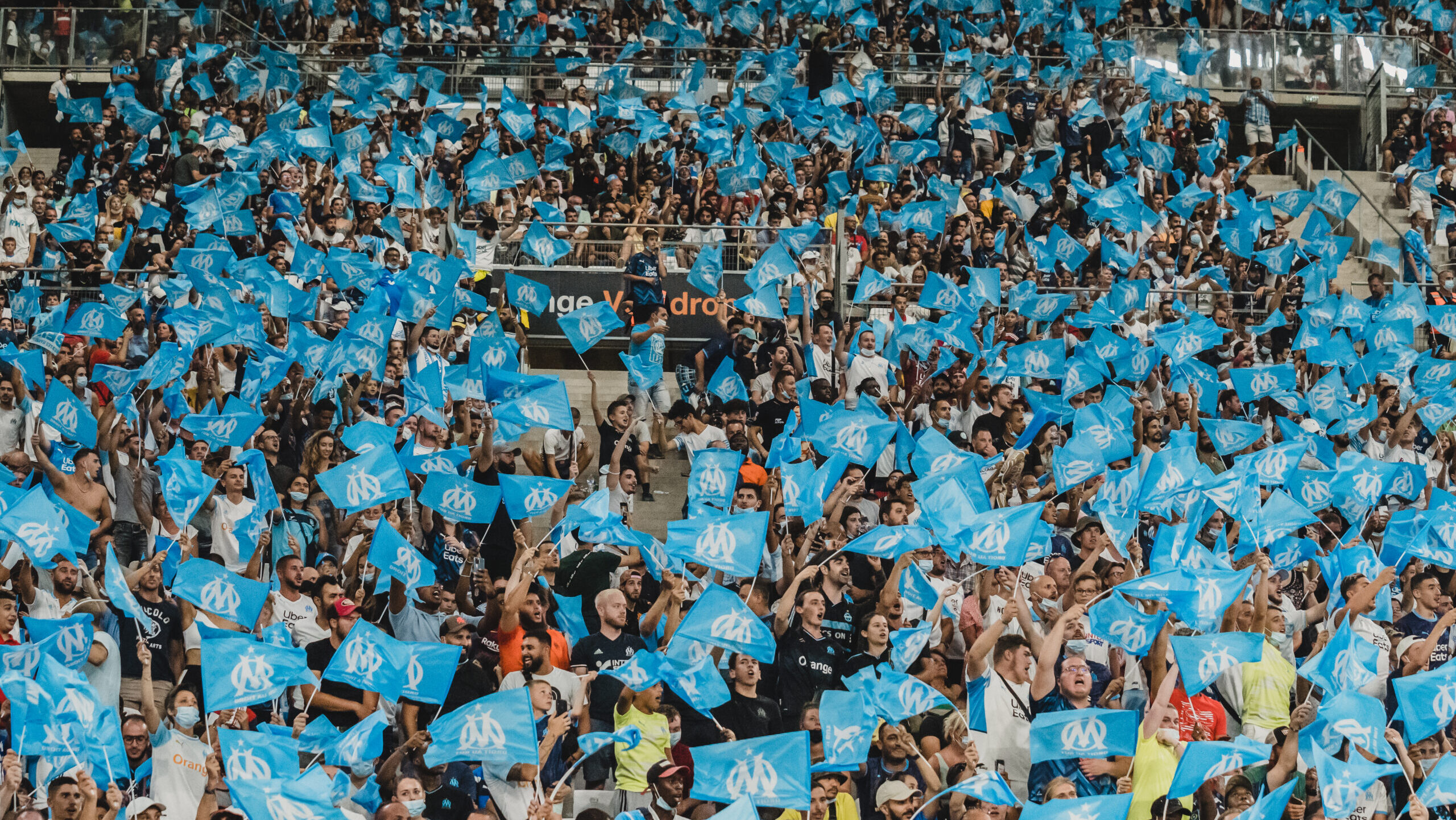 Fans in the Orange Velodrome waiving Olympique de Marseille flags